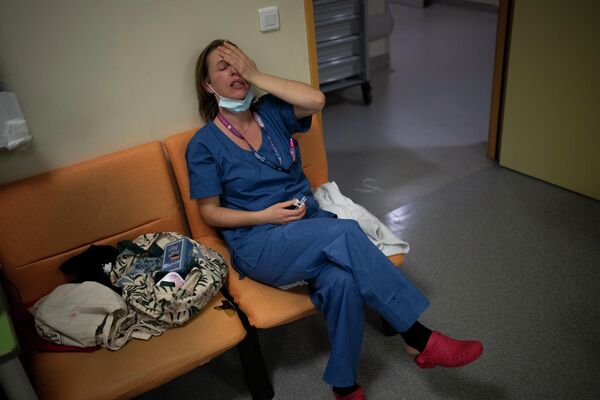 2021年12月31日星期五，在法国南部马赛的拉蒂莫内医院的 新冠肺炎重症监护病房，护士 玛丽-洛尔·萨塔在新年前夜轮班期间休息。新冠疫情导致的全球官方死亡人数正在突破600万的边缘——这显示出，目前已进入第三个年头的疫情还远未结束。 - 俄罗斯卫星通讯社