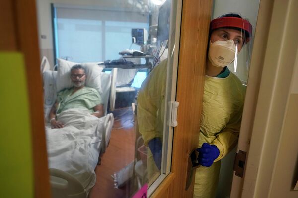 2022年1月3日周一，新罕布什尔州黎巴嫩达特茅斯-希区柯克医疗中心，注册护士瑞秋·钱伯林走出弗雷德·卢瑟福新冠肺炎康复隔离室。官方公布的全球新冠肺炎死亡人数即将超过600万，表明这场目前已进入第三个年头的疫情远未结束。 - 俄罗斯卫星通讯社