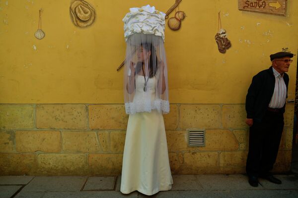 一位“少女”頭頂一個蓋著白布的籃子在“聖餅遊行”運送一塊麵包,該儀式旨在紀念聖多明戈·德拉·卡爾扎達(1019 - 1109)，他曾幫助窮人並朝聖。聖多明戈·德拉公路,西班牙北部,2022年5月11日週三。由於新冠肺炎疫情的限制，距離上次舉行儀式已經2年了。 - 俄羅斯衛星通訊社
