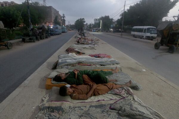 2022年5月11日週三，巴基斯坦卡拉奇，工人們在一個初夏的早晨睡在道路中間。巴基斯坦港口城市卡拉奇和該國其他一些地區在這些天內持續經歷強烈的熱浪。 - 俄羅斯衛星通訊社