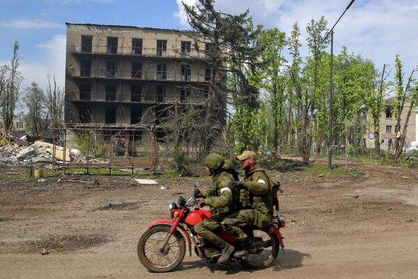 士兵們騎著摩托車經過波帕斯納亞鎮被毀的房屋。 - 俄羅斯衛星通訊社