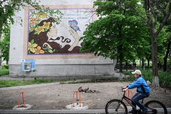 马里乌波尔市一男孩在街道上骑行自行车。 - 俄罗斯卫星通讯社