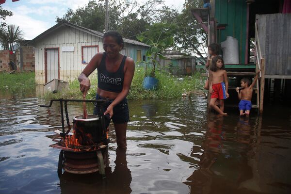 2022年5月23日，在巴西亞馬孫州，一名女性在被內格羅河洪水淹沒的家門口為家人做飯。 - 俄羅斯衛星通訊社