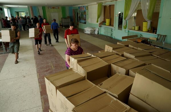 当地居民在鲁比日内的援助发放点卸下一箱又一箱的人道主义援助物资。 - 俄罗斯卫星通讯社