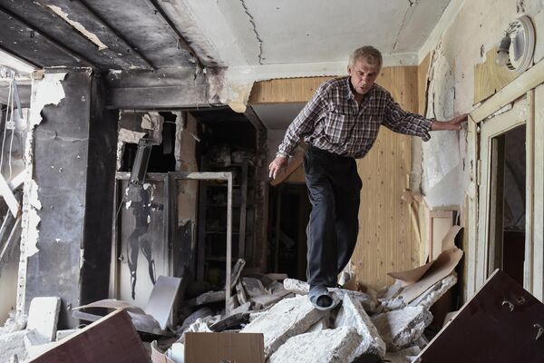 一名男子在馬里烏波爾一棟被毀壞的房屋裡。 - 俄羅斯衛星通訊社