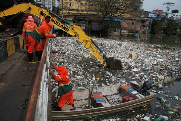 2022年6月6日，在巴西亚马逊州首府马瑙斯，城市工人清除漂浮在内格罗河上的垃圾，受下雨影响，河流水位上升。据悉，每天约有35吨的垃圾从水中被清除。 - 俄罗斯卫星通讯社