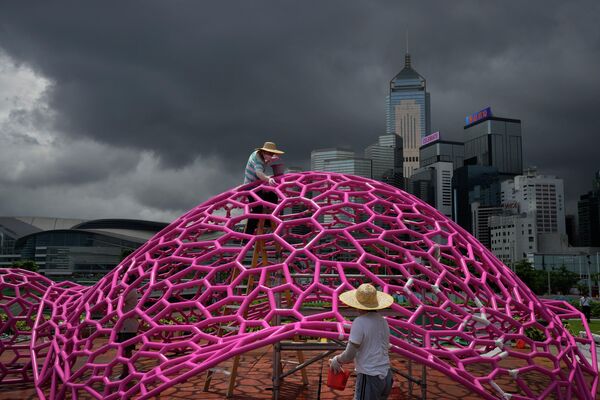 2022年6月6日，为庆祝香港回归25周年，工人们戴着口罩在海滨公园绘制以科学为主题的艺术装置。 - 俄罗斯卫星通讯社