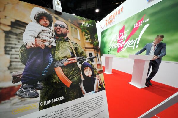 俄羅斯人民陣線運動展台，海報上展示了一名帶著兩個孩子的頓巴斯軍人。 - 俄羅斯衛星通訊社