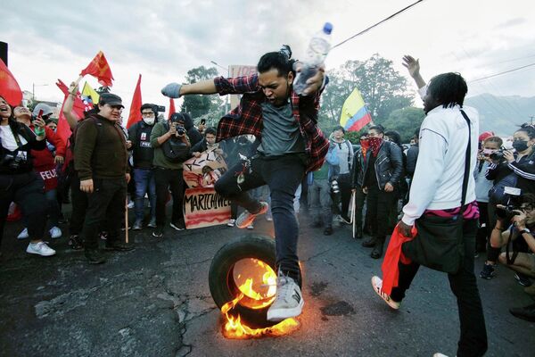 2022年6月14日，厄瓜多尔基多市中心，一名大学生在当地土著领导的反对总统吉列尔莫·拉索的示威活动中跃过一个燃烧的轮胎。厄瓜多尔警方于6月14日宣布逮捕一位高级土著领导人Leonidas Iza，他带头发起了一场全国性的抗议高油价运动。 - 俄罗斯卫星通讯社