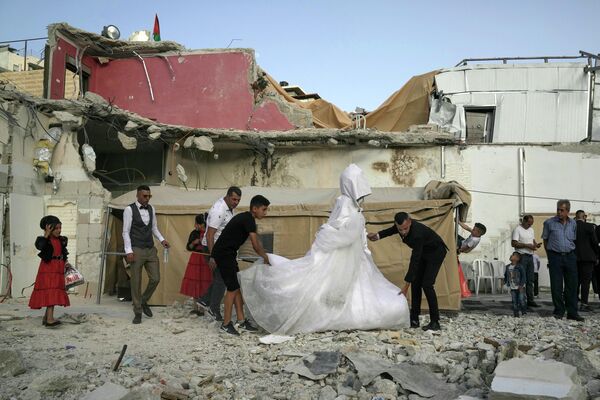 2022年6月11日，巴勒斯坦新娘Rabiha al-Rajby和新郎Mohyeldin Nasrallah在东耶路撒冷Silwan社区的住宅废墟上开始他们的婚礼仪式。以色列当局上个月拆除了该建筑，称该建筑是在没有市政许可的情况下建造的。该举措致使35名居民流离失所。 - 俄罗斯卫星通讯社