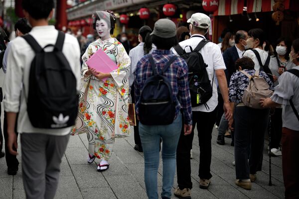2022年6月10日，東京一名身著日本傳統和服的藝妓沿著淺草區的一條商業街行走。日本放寬了對外國遊客的限制，但只面向那些願意佩戴口罩和採取其他防護措施的導遊團——日本試圖謹慎地在發展商業和控制感染之間尋找平衡。 - 俄羅斯衛星通訊社