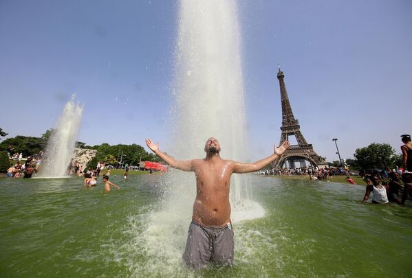 一名男子在冷卻巴黎埃菲爾鐵塔前的特洛卡德羅噴泉中偷涼。 - 俄羅斯衛星通訊社