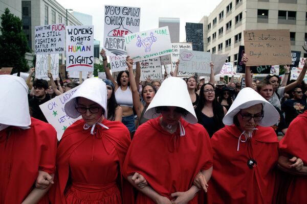 美国最高法院6月24日推翻有关女性堕胎合宪权的“罗诉韦德案”。2022年6月27日，美国科罗拉多州丹佛市的抗议人士穿着《使女的故事》中的标志性服装举行游行。 - 俄罗斯卫星通讯社