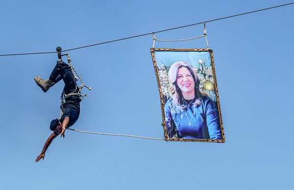 2022年6月30日，在加沙地帶南部汗尤尼斯，巴勒斯坦伊斯蘭抵抗運動(哈馬斯)武裝人員在警察學校畢業典禮上展示自己的技能。他拉出了被殺害的卡塔爾半島電視台知名女記者希琳·阿布·阿克利赫的照片。 - 俄羅斯衛星通訊社