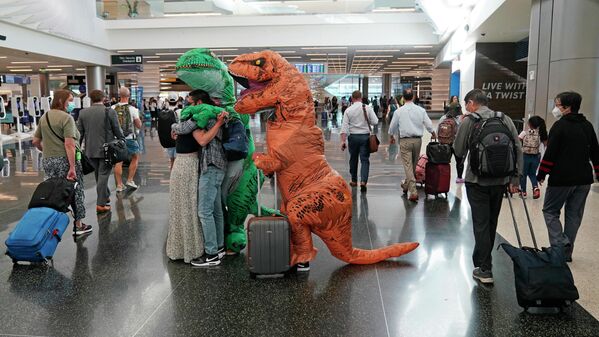 2022年6月27日，鹽湖城國際機場，兩個人裝扮成恐龍迎接朋友。 - 俄羅斯衛星通訊社