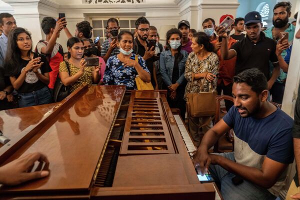 一名男子正在斯里蘭卡總統府內彈奏鋼琴。 - 俄羅斯衛星通訊社