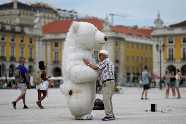 一名男子在里斯本商業廣場與一名穿著北極熊服裝的男子交談。 - 俄羅斯衛星通訊社
