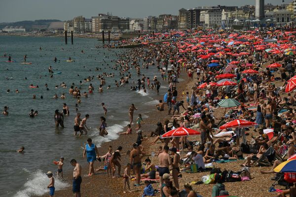 7月17日，遊客們在英格蘭南部布萊頓的海灘上曬太陽，在海裡游泳。英國氣象局於上週五發佈了紅色高溫預警，預計下周氣溫將達到創紀錄的 40 攝氏度。 - 俄羅斯衛星通訊社