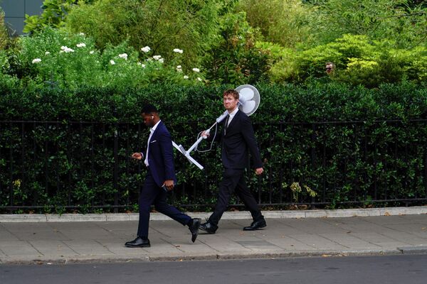 7 月 12 日，一名手持風扇的男子走出倫敦議會大廈。英國氣象局表示，本週首都的氣溫預計為 29 度，週末氣溫將達到 31 度。 - 俄羅斯衛星通訊社