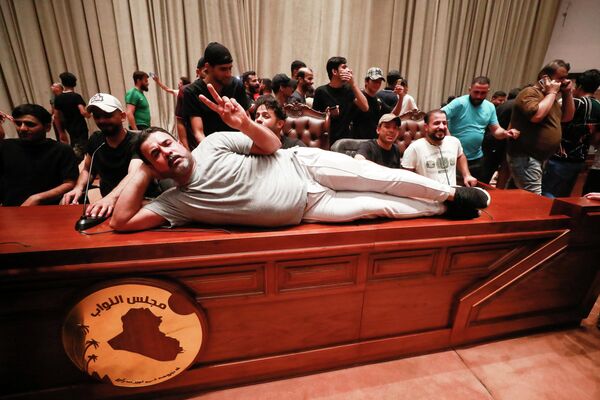 伊拉克什葉派宗教領袖穆克塔達·薩德爾的支持者躺在伊拉克議會議長的桌子上。 - 俄羅斯衛星通訊社