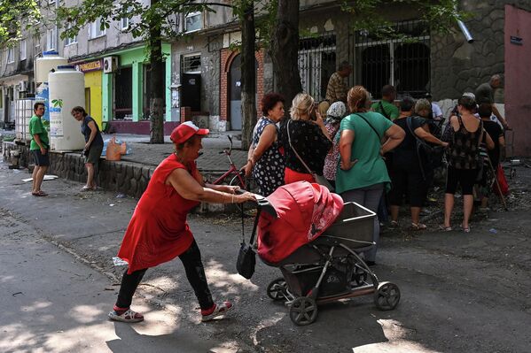马里乌波尔居民在一栋居民楼的院子里排队等待图拉州提供的人道主义援助。应居民们需求，志愿者还分发了婴儿纸尿裤、个人护理用品和日化用品。对于行动不便的居民，志愿者将人道主义援助送到他们的家中。 - 俄罗斯卫星通讯社