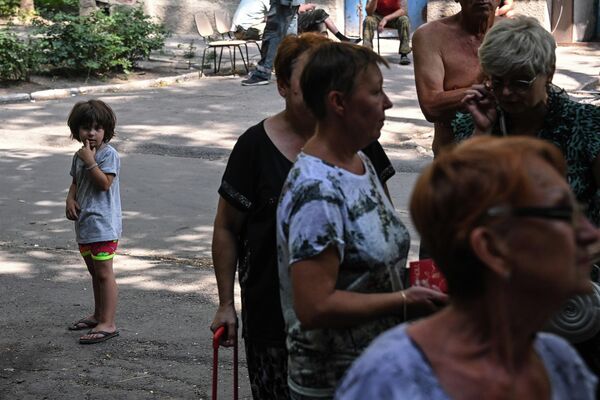 马里乌波尔的居民排队等待图拉州提供的人道主义援助。每份援助重约10公斤：包括谷物、糖、通心粉、面粉、植物油、罐头食品、咖啡和茶、饮用水以及糖果，其中包括图拉蜜糖饼。 - 俄罗斯卫星通讯社