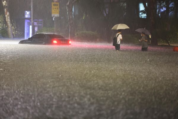 8月8日，首尔市民在大雨淹没的街道中涉水出行。 - 俄罗斯卫星通讯社