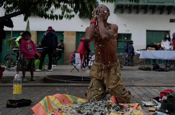 哥倫比亞波哥大市中心，一名街頭藝人正在臉上擦玻璃碎片。 - 俄羅斯衛星通訊社