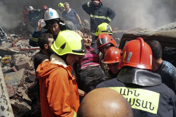 2022年8月14日星期日，亚美尼亚埃里温市中心以南约两公里（1.2英里）的“Surmalu”购物中心火灾现场，消防员正在疏散一名受伤的妇女。一个存放烟花材料的仓库发生的强烈爆炸炸毁了亚美尼亚首都的一个市场。至少有一人死亡，另有约20人受伤。周日的爆炸引发了一场大火。(法新社图片/Daniel Bolshakov) - 俄罗斯卫星通讯社