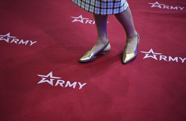 一名女孩站在印有“军队-2022”论坛标志的地毯上。 - 俄罗斯卫星通讯社