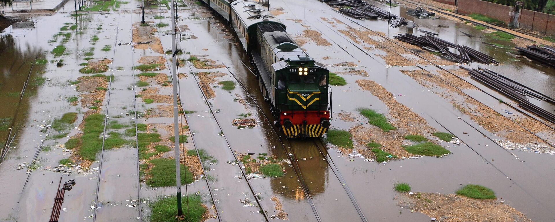 Поезд движется по затопленным железнодорожным путям после сильных муссонных дождей в Хайдарабаде  - 俄罗斯卫星通讯社, 1920, 31.08.2022