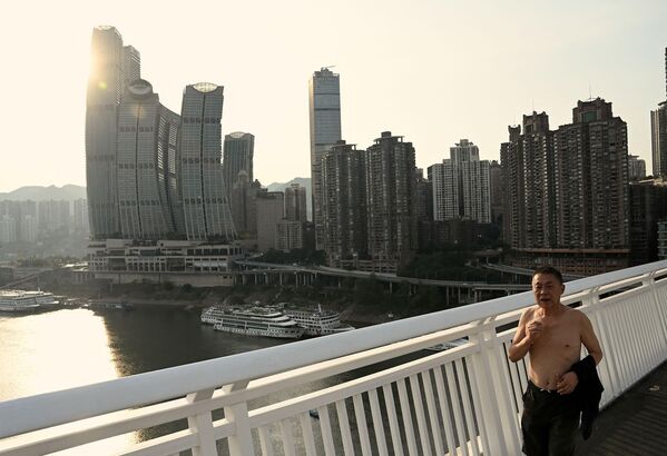 中國西南部城市重慶，一名男子沿著一座橋走過嘉陵江乾涸的河床。 - 俄羅斯衛星通訊社