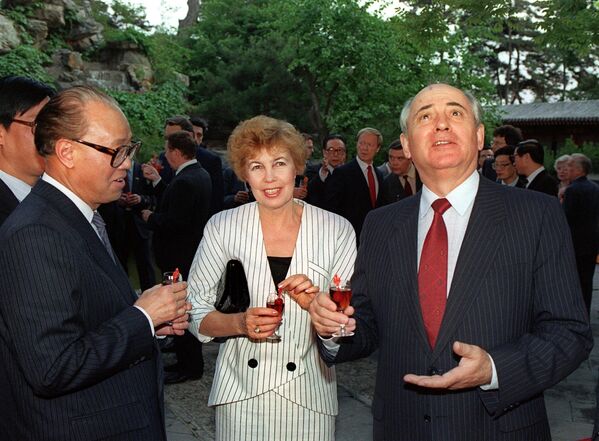 1989年5月16日，苏共中央总书记米哈伊尔·戈尔巴乔夫（右）在北京与记者交谈时打手势，中国国务院总理和中共中央总书记赵紫阳（左）和赖莎·戈尔巴乔娃在一旁观看。 - 俄罗斯卫星通讯社