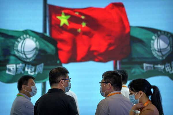 2022年9月2日，周五，中国国家电网公司的展台上，人们站在中国国旗和公司的旗帜飘扬的视频屏幕附近。 - 俄罗斯卫星通讯社