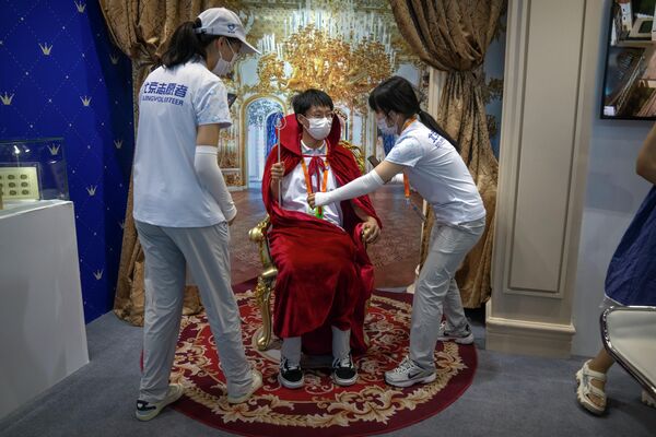中国国际服务贸易交易会期间志愿者们在帮助一名志愿者穿上西装。 - 俄罗斯卫星通讯社