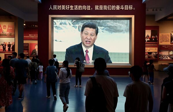 2022年9月4日，在中国共产党历史展览馆，人们在放有中国国家主席习近平的屏幕前走过。(Photo by Noel Celis / AFP) - 俄罗斯卫星通讯社