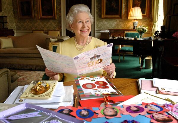 2006 年 4 月 19 日，英国女王伊丽莎白二世坐在伦敦白金汉宫的摄政室阅看她80岁生日发送给她的一些贺卡。 - 俄罗斯卫星通讯社