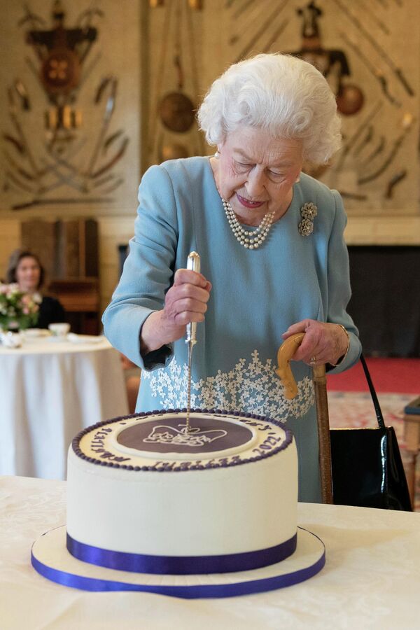 2022 年2 月 5 日，英國女王伊麗莎白二世在英格蘭桑德靈厄姆她在諾福克郡的桑德靈厄姆莊園切蛋糕慶祝白金禧年的開始。 - 俄羅斯衛星通訊社