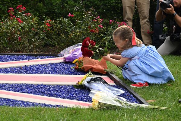 一个女孩将一束鲜花放在英国驻华盛顿大使馆外的英国国旗上。 - 俄罗斯卫星通讯社