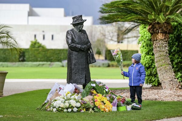 10 歲男孩在阿德萊德政府大樓的英國女王雕像底座上獻花。 - 俄羅斯衛星通訊社