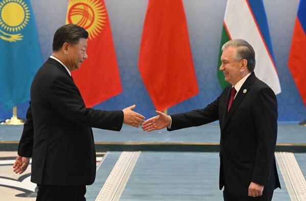 乌兹别克斯坦总统米尔济约耶夫（右）与中国国家主席习近平在上合组织成员国元首的合影仪式前 - 俄罗斯卫星通讯社