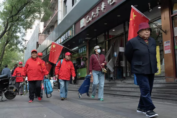 走在北京街道上的行人。北京的街道兩側懸掛國旗,喜迎二十大。 走在北京街道上的行人。北京的街道兩側懸掛國旗,喜迎二十大。 - 俄羅斯衛星通訊社