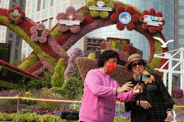 居民在北京的街心花園前合影。 - 俄羅斯衛星通訊社