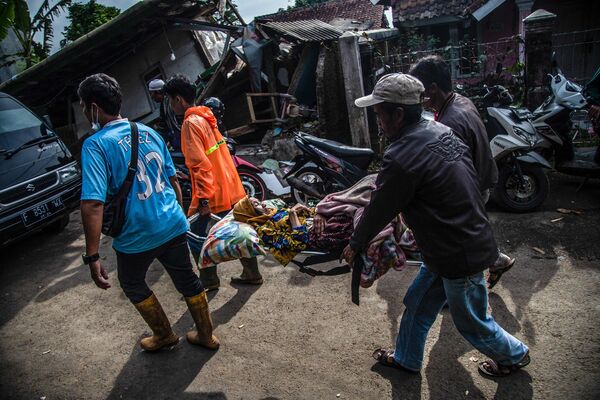 印度尼西亞西爪哇省展玉地區居民正在搬運傷員。 - 俄羅斯衛星通訊社