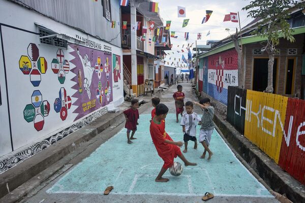 11月20日，在印尼蘇拉威西島的Pambusuang村，孩子們在卡塔爾世界杯主題壁畫附近踢足球。 - 俄羅斯衛星通訊社