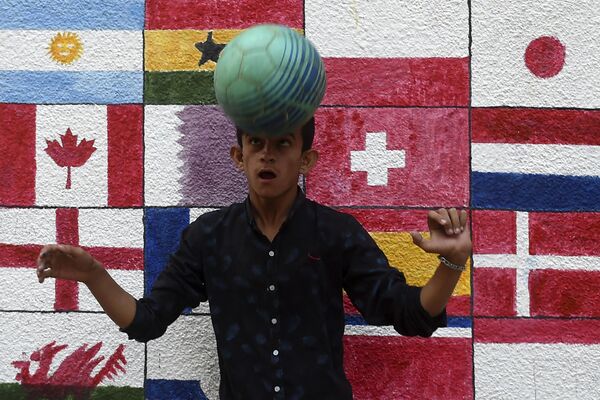 11月7日，在卡拉奇的一条街上，一名男孩在一幅壁画前踢足球。 - 俄罗斯卫星通讯社