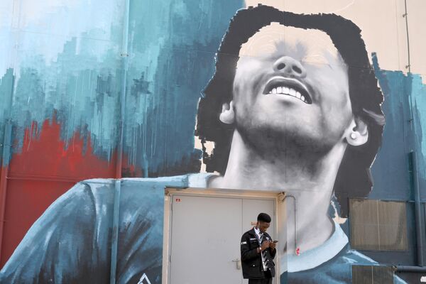 11月15日，2022年卡塔尔世界杯开幕前夕，一名男子站在描绘阿根廷传奇球星马拉多纳的壁画前。 - 俄罗斯卫星通讯社
