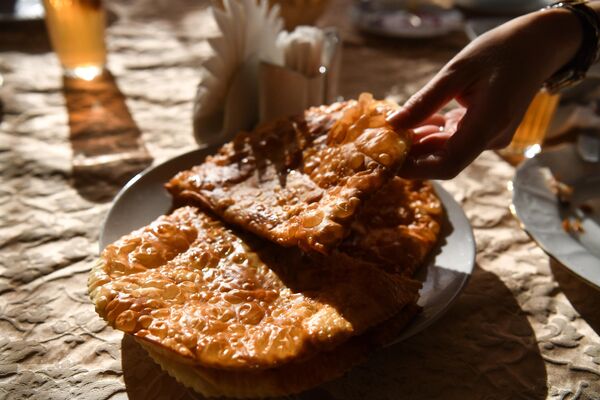 “科学之旅：索契”的一名参与者在索契一家传奇馅饼餐馆品尝羊肉馅饼。 - 俄罗斯卫星通讯社