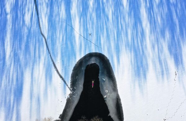 2022年12月3日，中国东北辽宁省沈阳市降雪后，一名冬泳爱好者在半结冰的湖中游泳。  - 俄罗斯卫星通讯社