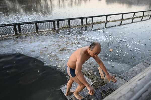 2022年12月4 日，一名男子在北京什刹海公园部分结冰的湖中游泳后从水中出来。 - 俄罗斯卫星通讯社